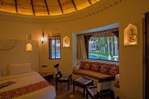 拉杰果德Nirali Resorts的一间卧室设有一张床和一个窗口