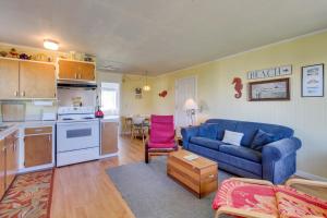 莫克利普斯Driftwood Cottage的一间带蓝色沙发的客厅和一间厨房