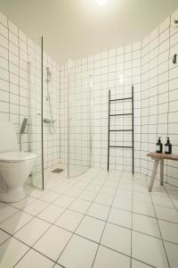 ÅmotStilleben Hotell的白色瓷砖浴室设有卫生间和淋浴。