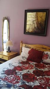 姆巴巴内Otentik guesthouse的一间卧室配有一张带花卉被子的床