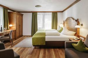 蒂罗尔-泽费尔德海蒙酒店的配有一张床和一张书桌的酒店客房