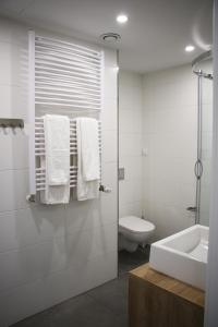 波兹南Lemon Plaza Hotel的白色的浴室设有水槽和卫生间。