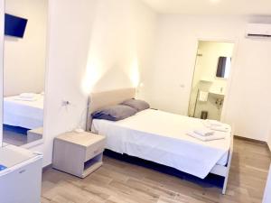 菲乌米奇诺阿克黛米酒店的白色卧室配有床和镜子