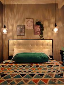 梭罗Shofiya Guesthouse Solo的一间卧室配有一张绿床和两盏吊灯