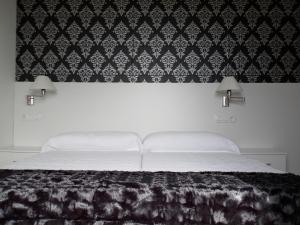 朗格勒埃斯特雷亚阿莱玛公寓的一间卧室配有一张黑色和白色壁纸的床