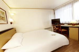 登博斯斯海尔托亨博斯钟楼酒店及餐厅的一间酒店客房,配有一张白色的床和一张书桌