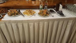 米西姆纳Hotel Adonis的一张桌子,上面放着几盘食物