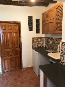 潘潘埃拉CASA M'GUIRE的厨房设有木门和水槽