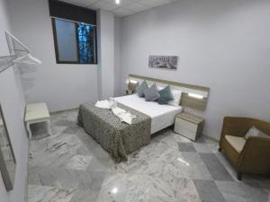 科尔多瓦Apartamento Capuchinos Cordoba的一间卧室配有一张床、一张沙发和一把椅子