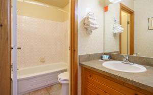 萨斯喀彻温河渡口可若酒店的一间带水槽、浴缸和卫生间的浴室