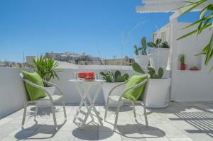 纳克索乔拉阿德里安尼酒店的阳台配有桌椅和植物