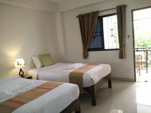 清迈Rena House Chiang Mai的酒店客房设有两张床和窗户。