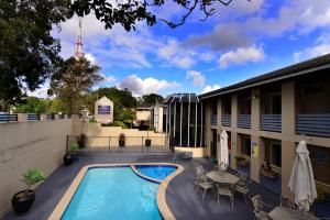 悉尼双塔酒店的一座带桌椅的游泳池位于酒店大楼旁