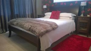 汉密尔顿科贝伦住宿加早餐旅馆的一间卧室配有一张带毛皮毯子和枕头的床。