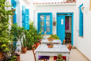 北尼科西亚塞浦路斯燕子精品住宿加早餐旅馆的庭院设有蓝色百叶窗和桌椅
