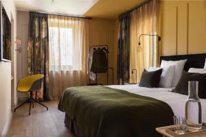 马格朗ANNEXE 1888的一间卧室配有一张带绿毯的大床