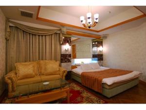 丰中Hotel ShaSha Toyonaka (Adult Only)的一间卧室配有一张床和一张沙发
