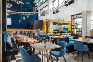 布达佩斯D8 Hotel的餐厅设有木桌和蓝色椅子