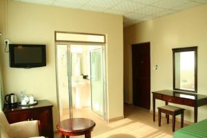 Kitwe莫巴酒店及会议中心的带电视的客厅和带书桌的房间。