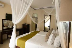 维多利亚瀑布维多利亚瀑布长虹饭店的一间卧室配有一张带白色窗帘和镜子的床