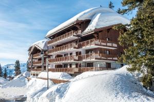 拉赫兹耶尔CGH Résidences & Spas Chalet Les Marmottons的一座有雪盖屋顶的建筑,位于雪盖地面上