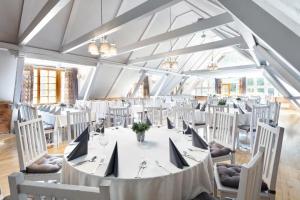 斯武普斯克多琳娜夏洛特Spa度假村的一间大型用餐室,配有白色的桌子和椅子