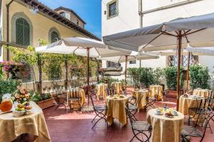 佛罗伦萨帕里斯酒店的一个带桌椅和遮阳伞的庭院