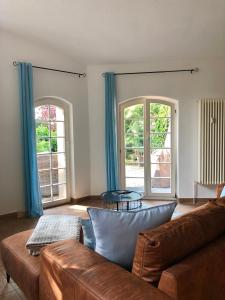 德累斯顿Ferienwohnung am Wasser Villa Graf von Pfeil的带沙发和2扇窗户的客厅