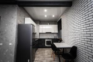 卡缅斯科耶Loft Apartment on Svobody的厨房配有冰箱和桌椅