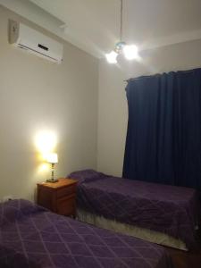 圣胡安Terra的一间卧室配有两张床和蓝色窗帘