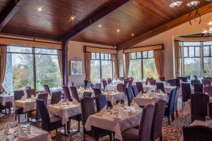 韦斯特波特韦斯特波特伍兹温泉酒店的宴会厅配有桌椅和窗户。