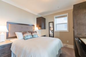苏克SookePoint Ocean Cottage Resort的卧室配有带枕头的白色床和窗户。