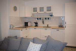 塔塔Buborék apartman的厨房配有白色橱柜和灰色沙发