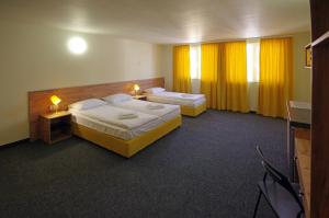 加布罗沃Стаи за Гости "ЦЕНТРАЛ" Фамилни Стаи & Апартаменти的配有黄色窗帘的酒店客房的两张床