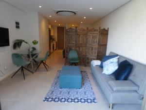 SibayaOcean Dune Studio的客厅配有蓝色的沙发和桌子