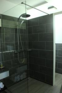 法兰西堡Studio Montgérald的浴室设有黑色瓷砖淋浴。