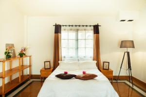 IvatoSomptua Garden的一间卧室配有一张带两个枕头的床