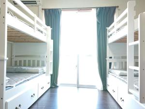 座间味村Yenn's Marina Inn Zamami Condominium的一间卧室设有双层床和窗户。