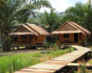 考索考索蓝山酒店的两间带木桥和棕榈树的小小屋