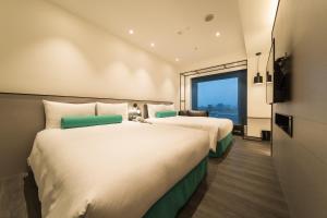 台北台北凯达大饭店的配有大窗户的酒店客房内的两张床