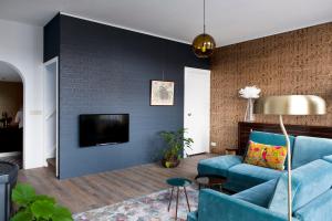阿森Rooftop 52, City-Apartment的客厅配有蓝色的沙发和电视