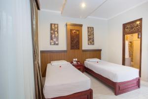 勒吉安Sinar Bali Hotel的带2张床的客房,位于带窗户的房间内