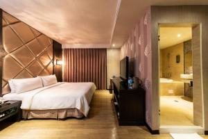 高雄日光河堤时尚旅店的一间卧室配有一张床、一台电视和一间浴室。
