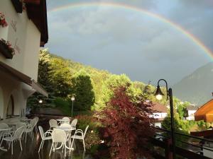 奥蒂塞伊Villa Luise的一个带桌椅的庭院上方有一个彩虹