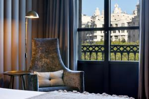 巴塞罗那巴塞罗那伯爵酒店的一间卧室配有椅子和大窗户
