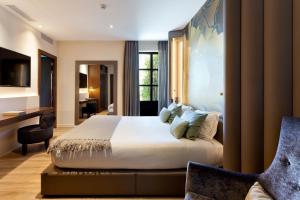 巴塞罗那巴塞罗那伯爵酒店的酒店客房设有一张大床和一张书桌。