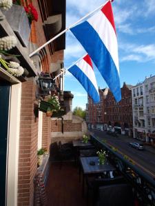 阿姆斯特丹克莱门斯酒店的悬挂在阳台的旗帜,带有桌子和街道