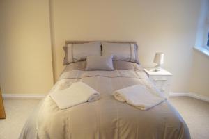 格拉斯哥Modern, Cosy Apartment In Bearsden with Private Parking的床上有两条白色毛巾