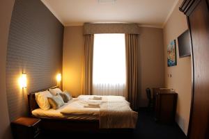 奥普尔卡米尼卡酒店的一间卧室设有一张大床和大窗户