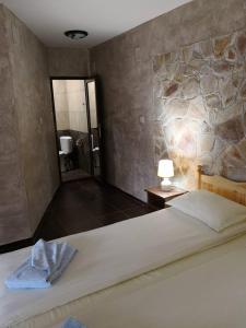 科普里夫什迪察Yurukovata kashta的一间卧室设有一张大床和石墙